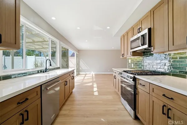 a kitchen with a sink a counter top space and stainless steel appliances