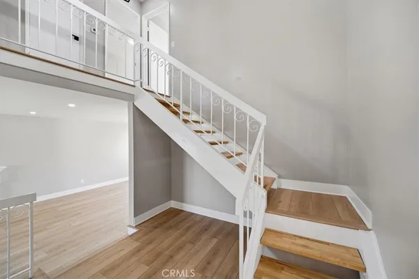 a view of staircase with railing and white walls