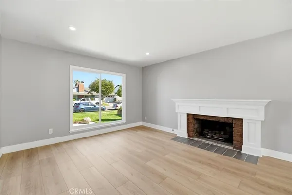 an empty room with windows and fireplace