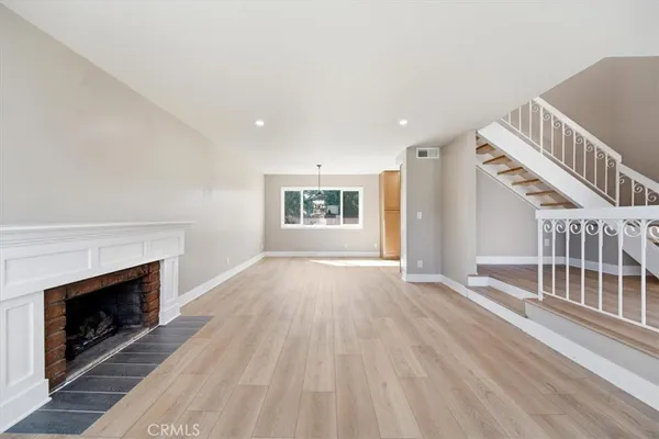 wooden floor fireplace and windows in an empty room
