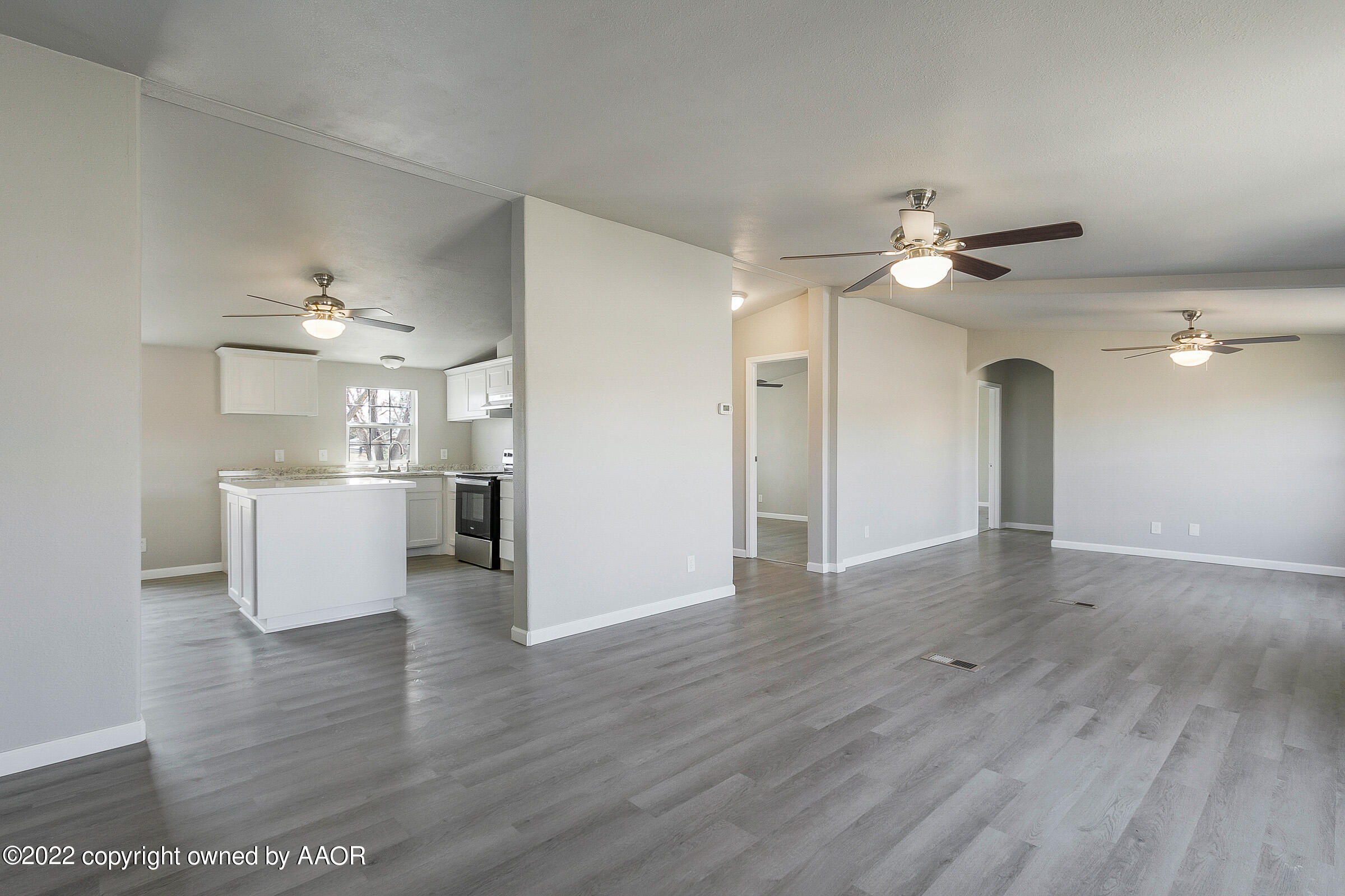 a view of an empty room with a kitchen
