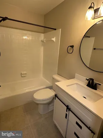 a bathroom with a sink mirror toilet and bathtub
