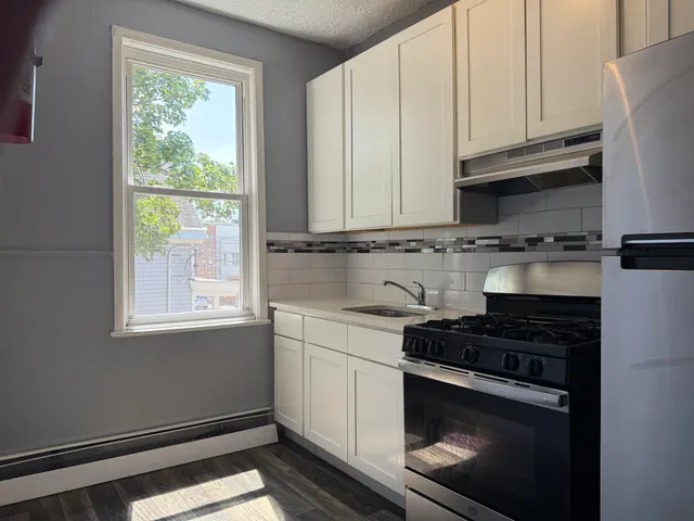 a kitchen with granite countertop white cabinets and window