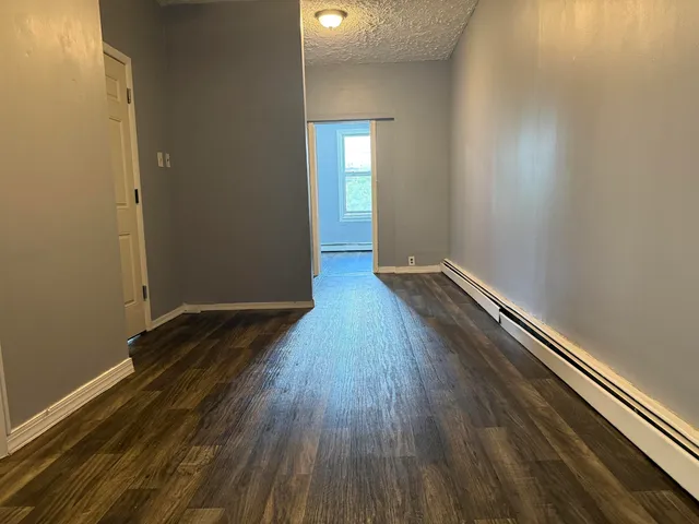 a view of a room with wooden floor