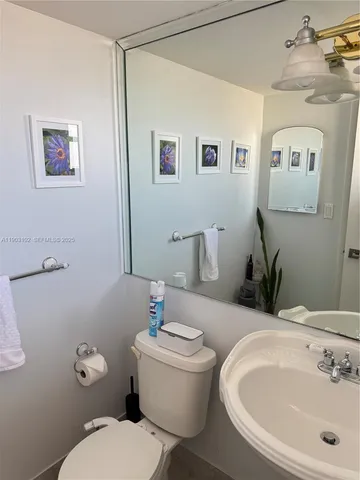 a bathroom with a toilet a sink and mirror