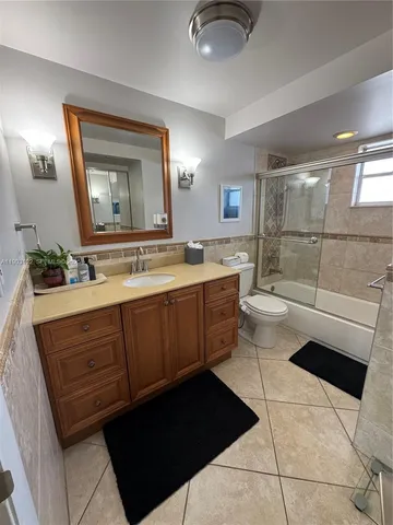 a bathroom with a sink a toilet a mirror and shower