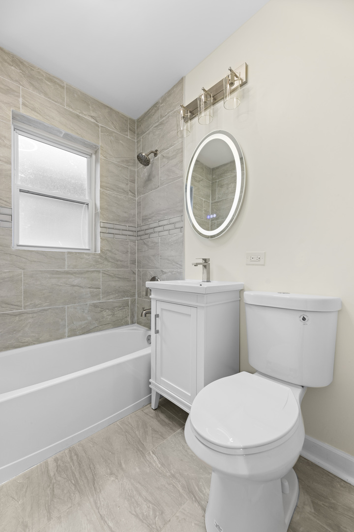 8946 South May Street Chicago, IL 60620 - Photo 12 of 23 a bathroom with a toilet a sink and a bathtub