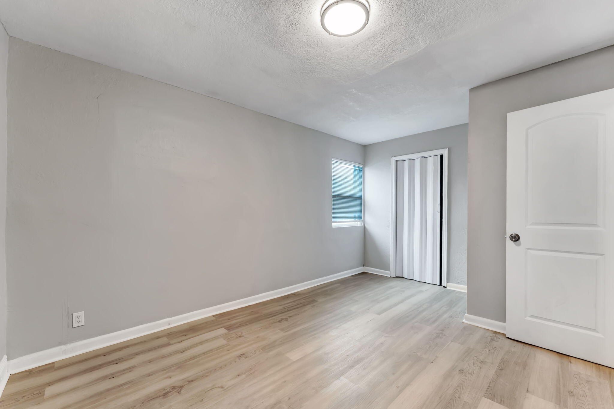 172 West 15th Street, Unit 1 Riviera Beach, FL 33404 - Photo 15 of 23 a view of an empty room with wooden floor and a window