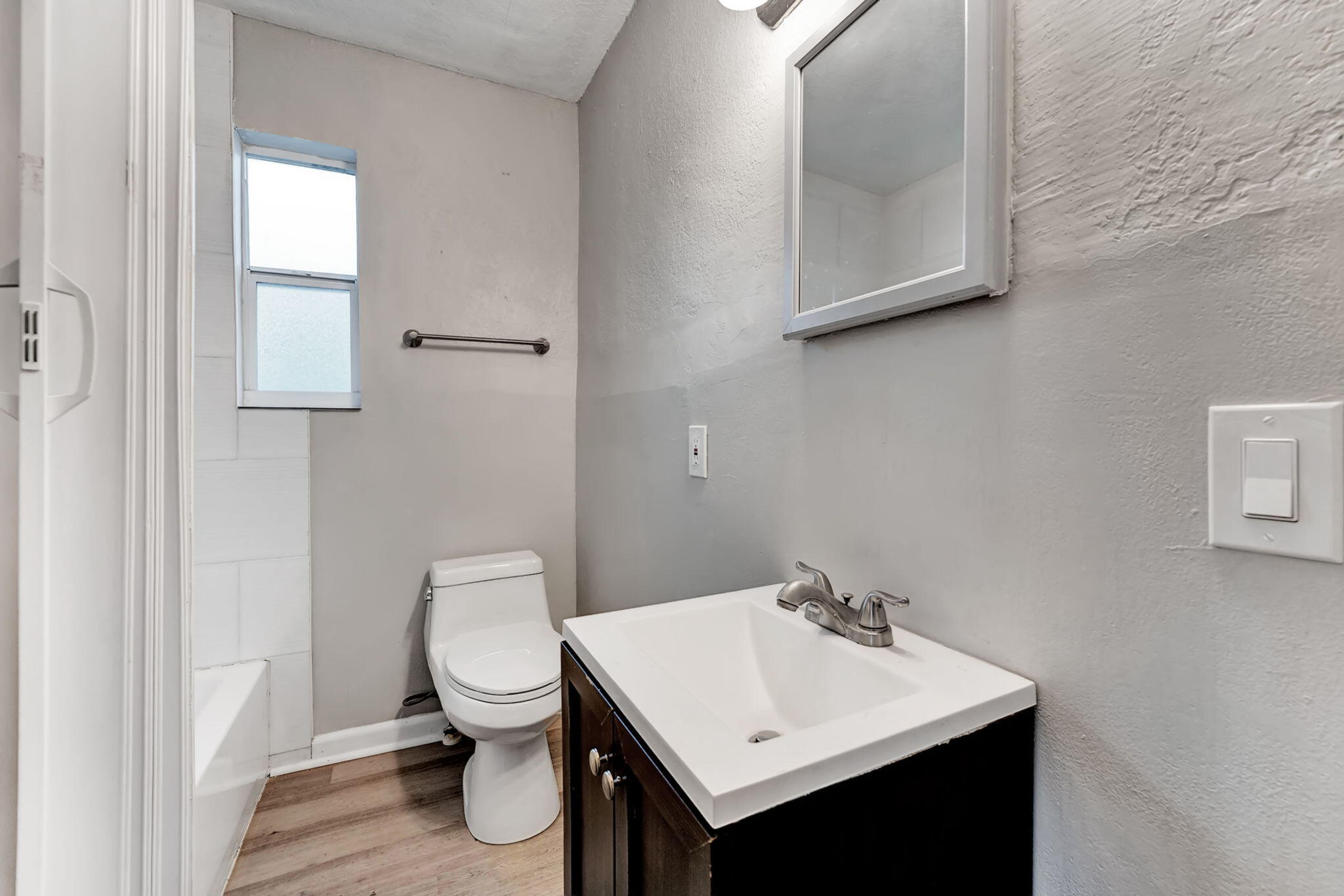 172 West 15th Street, Unit 1 Riviera Beach, FL 33404 - Photo 8 of 23 a bathroom with a toilet a sink and a mirror