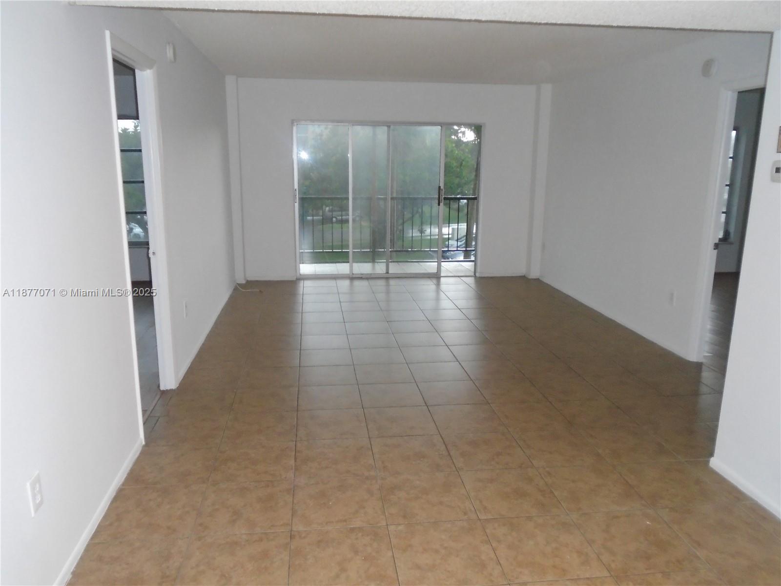 4174 Inverrary Drive, Unit 303 Lauderhill, FL 33319 - Photo 11 of 27 wooden floor in an empty room with a glass door