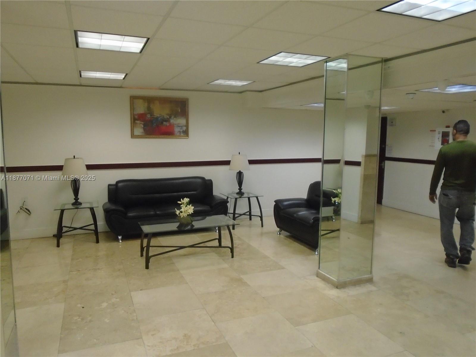 4174 Inverrary Drive, Unit 303 Lauderhill, FL 33319 - Photo 8 of 27 a living room with furniture a flat screen tv and a table