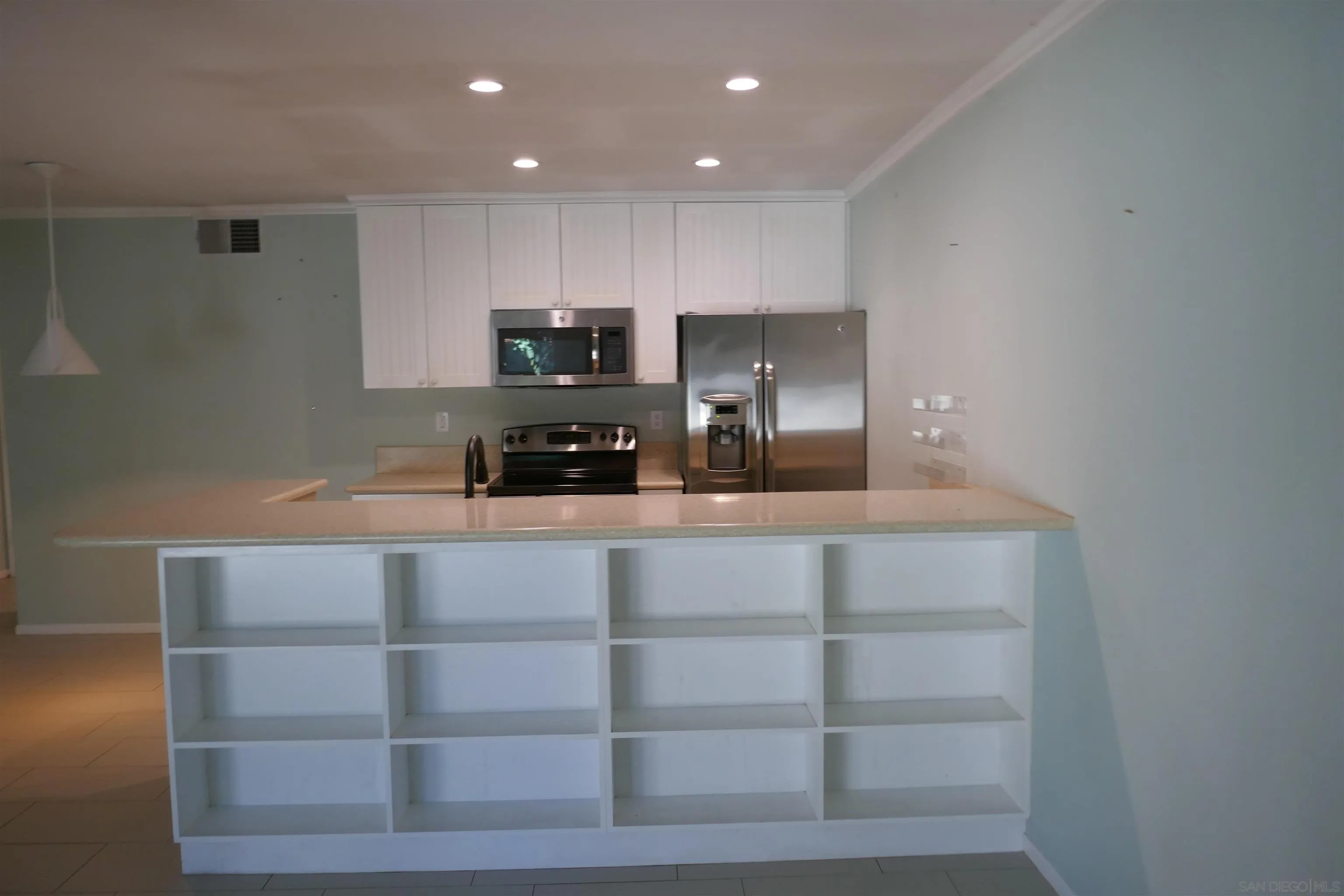 5989 Rancho Mission Road, Unit 201 San Diego, CA 92108 - Photo 2 of 14 a kitchen with kitchen island a refrigerator and a stove top oven
