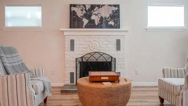 a living room with furniture a fireplace and wooden floor
