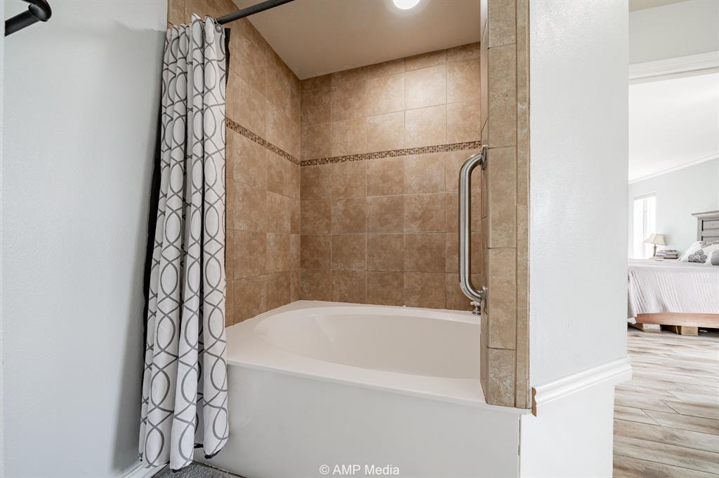 1869 Farm To Market Road 605 Hawley, TX 79525 - Photo 13 of 39 a bathroom with a bathtub and a shower