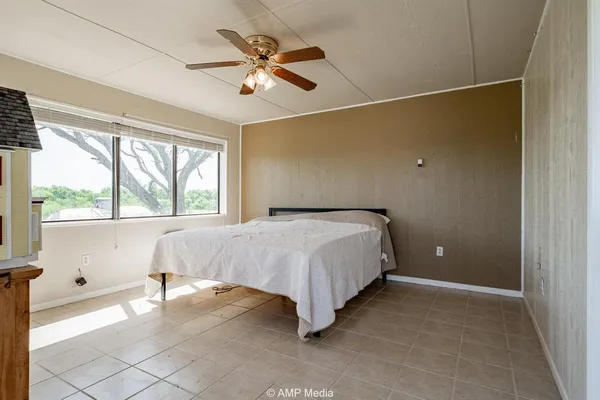 a spacious bedroom with a bed and a large window