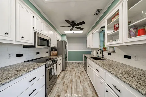 a kitchen with stainless steel appliances granite countertop a sink and a stove