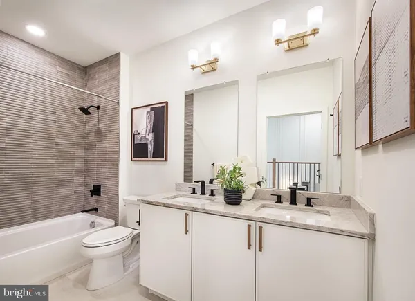 a bathroom with a granite countertop toilet sink and mirror