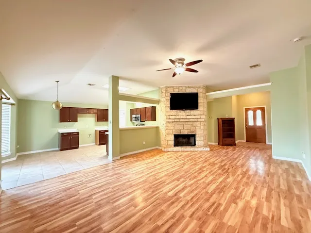 a view of a livingroom with a fireplace a chandelier and wooden floor