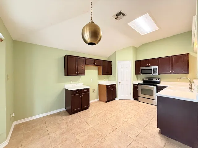 a kitchen with stainless steel appliances granite countertop a sink and a stove top oven