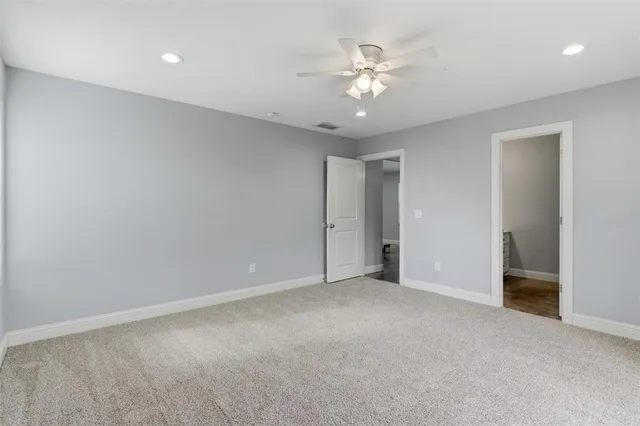 a view of an empty room with a chandelier fan