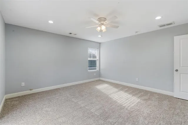 a view of an empty room with a chandelier fan