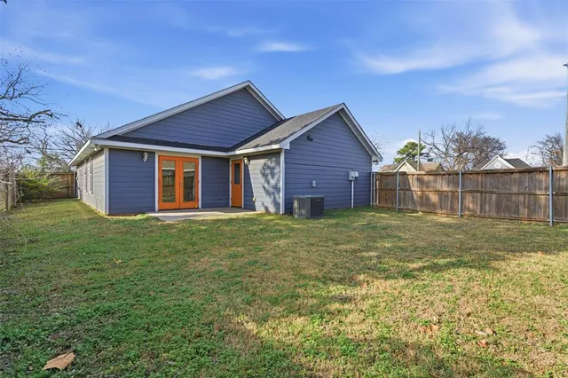 a view of a yard in front of a house with a large tree