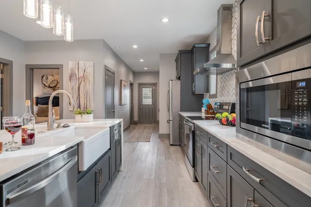 a kitchen with stainless steel appliances a sink stove and cabinets