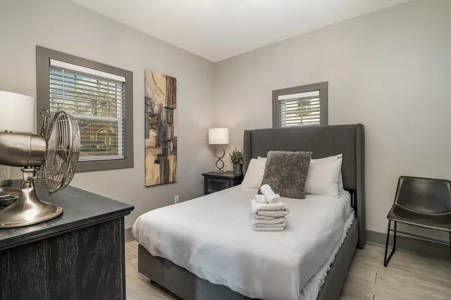 a bedroom with a bed and wooden floor