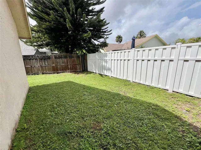 a view of a porch with a small yard and wooden fence