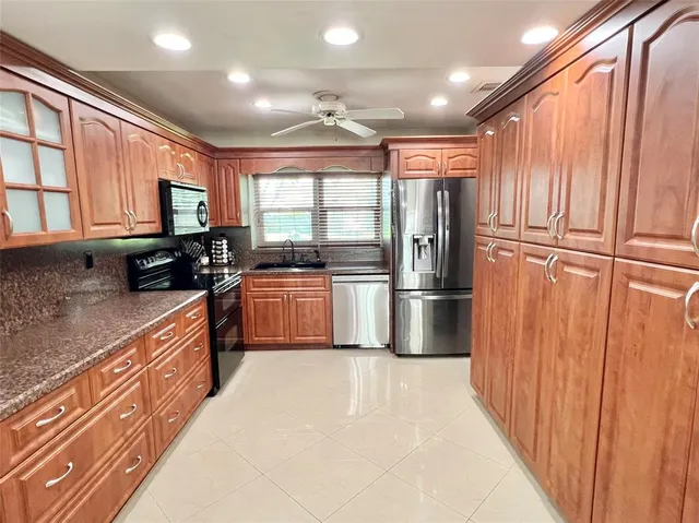 a kitchen with stainless steel appliances granite countertop a refrigerator a sink a stove a microwave and island