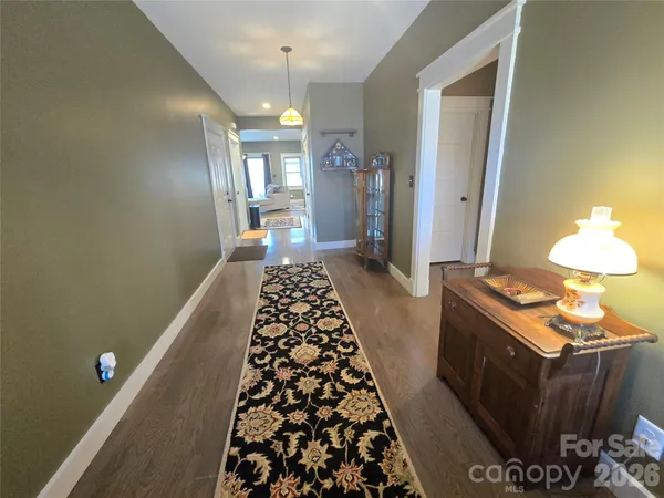 a large kitchen with stainless steel appliances granite countertop a stove a sink dishwasher a refrigerator and white cabinets with wooden floor