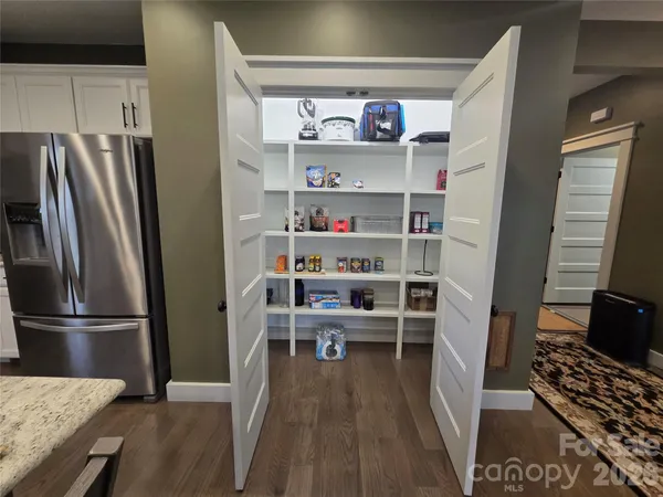 a kitchen with stainless steel appliances granite countertop a stove a sink dishwasher a dining table and chairs with wooden floor