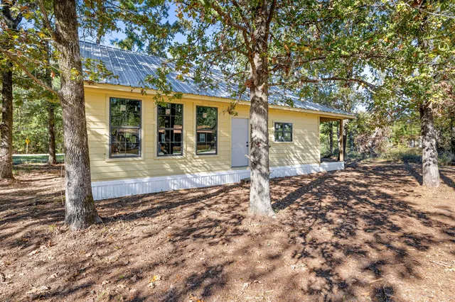 a front view of a house with a tree