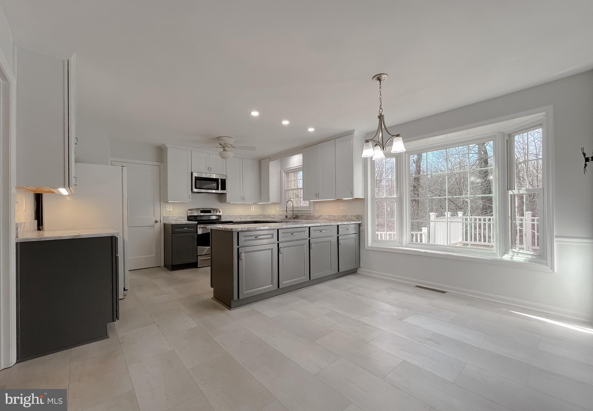 513 Clarks Run Road La Plata, MD 20646 - Photo 9 of 45 a open kitchen with kitchen island a sink dishwasher a stove and a refrigerator with wooden floor