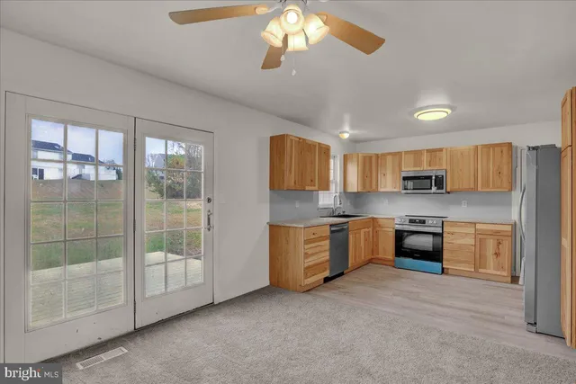 a large kitchen with a large window and stainless steel appliances