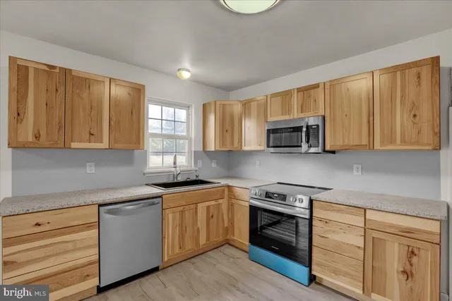 a kitchen with stainless steel appliances granite countertop a sink stove and microwave