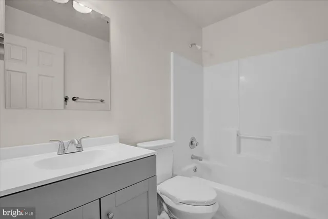 a bathroom with a sink toilet vanity and tub