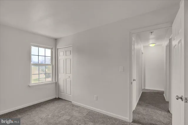 an empty room with windows and closet