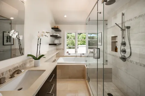 a bathroom with a double vanity sink mirror and shower