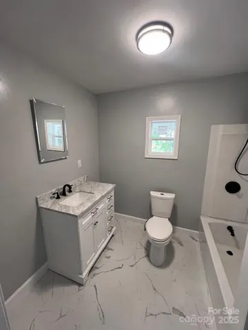 a bathroom with a sink toilet and window