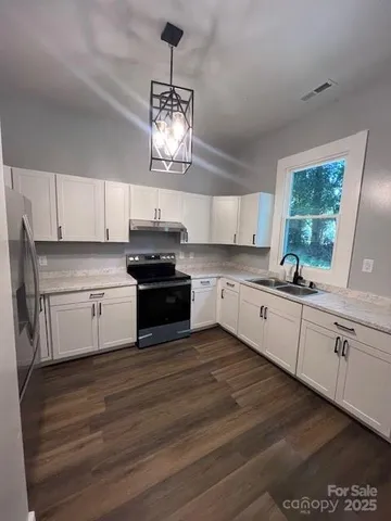 a kitchen with granite countertop stainless steel appliances cabinets a sink and a window