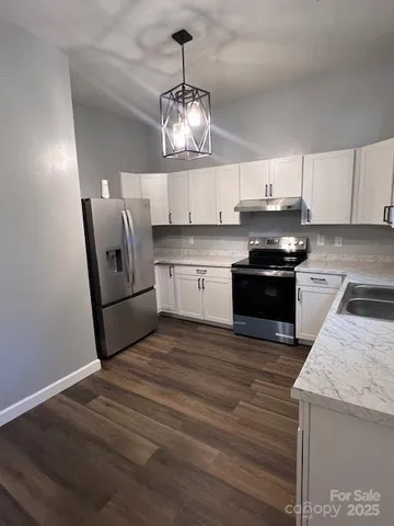 a kitchen with stainless steel appliances granite countertop a sink a stove a microwave and cabinets