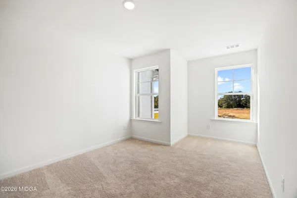 an empty room with windows and closet