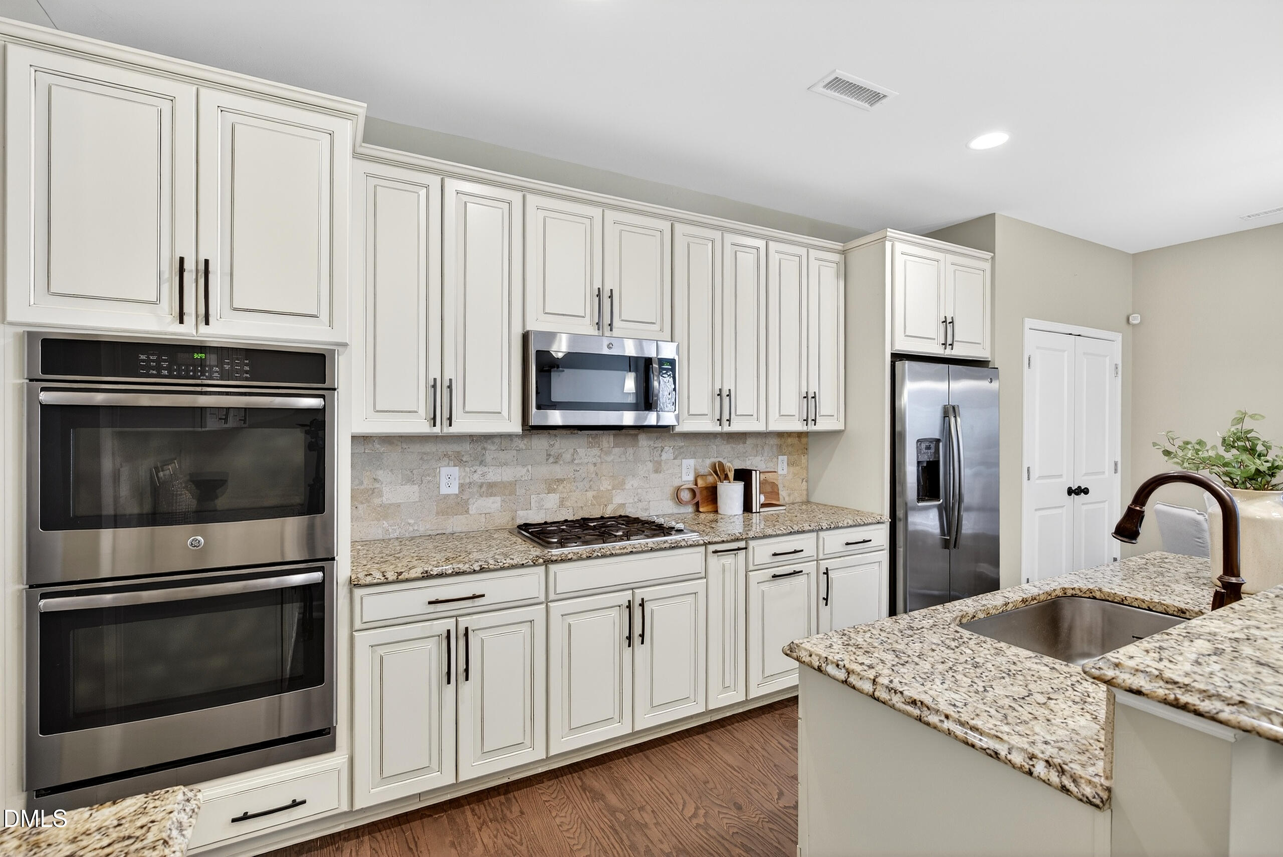 109 Willow View Lane Apex, NC 27539 - Photo 14 of 72 a kitchen with granite countertop white cabinets and stainless steel appliances