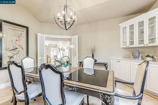 a view of a dining room with furniture a chandelier and wooden floor