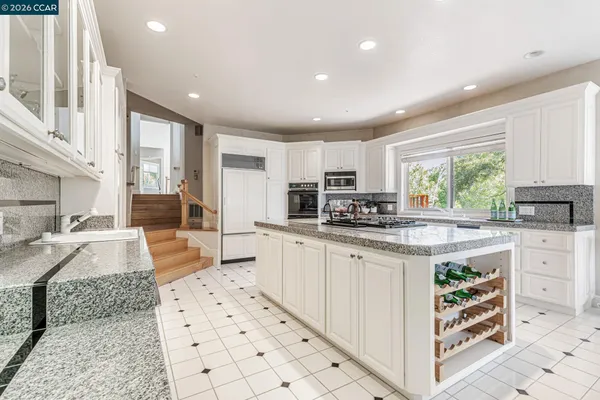 a kitchen with stainless steel appliances kitchen island granite countertop a sink and cabinets