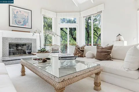 a living room with furniture large window and a fireplace