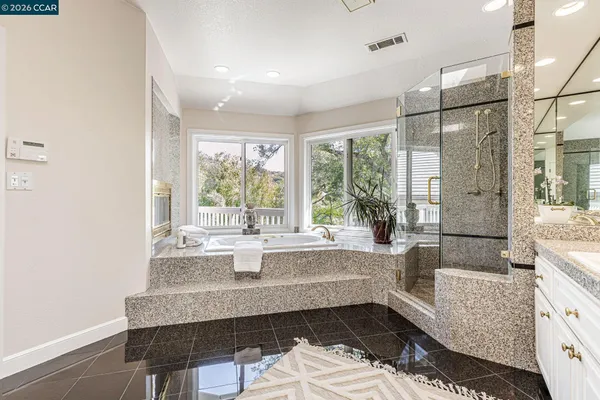 a spacious bathroom with a granite countertop sink and a mirror