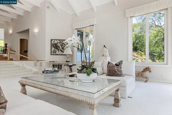 a dining room with furniture and large windows
