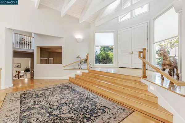 a view of a living room and a large window with wooden floor